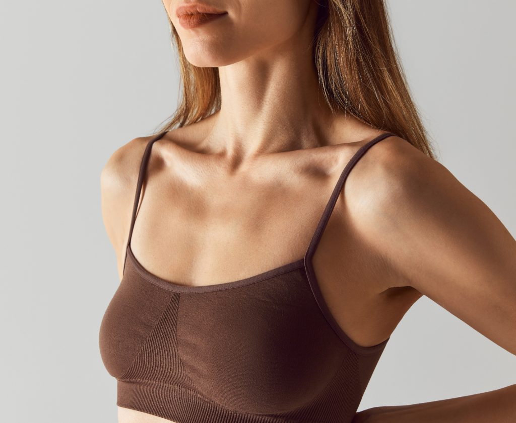 woman in brown sports bra smiling