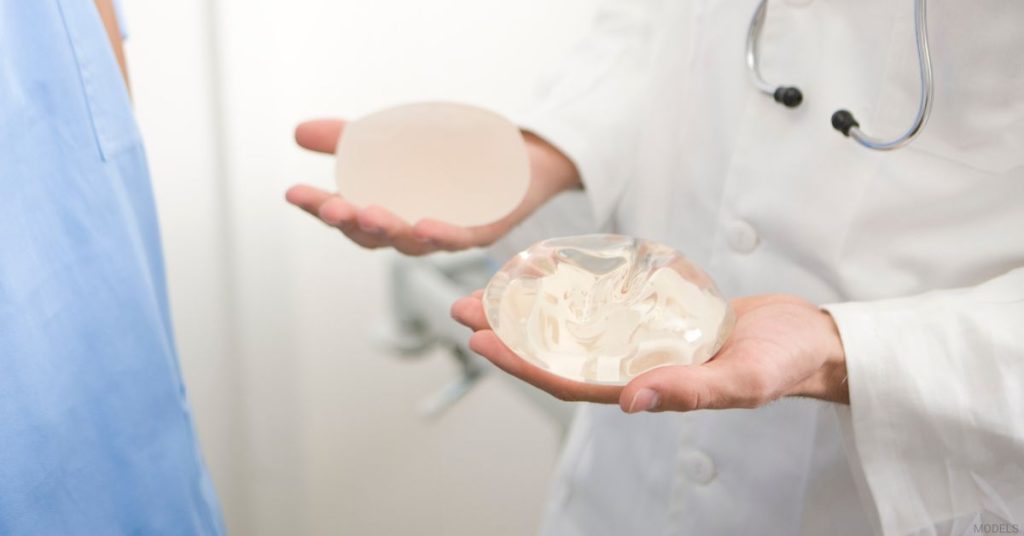 A doctor showing different breast implant types. (Models)